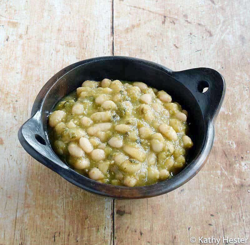Plant Based Instant Pot White Beans with Tomatillos and Poblanos in a dark pottery bowl.
