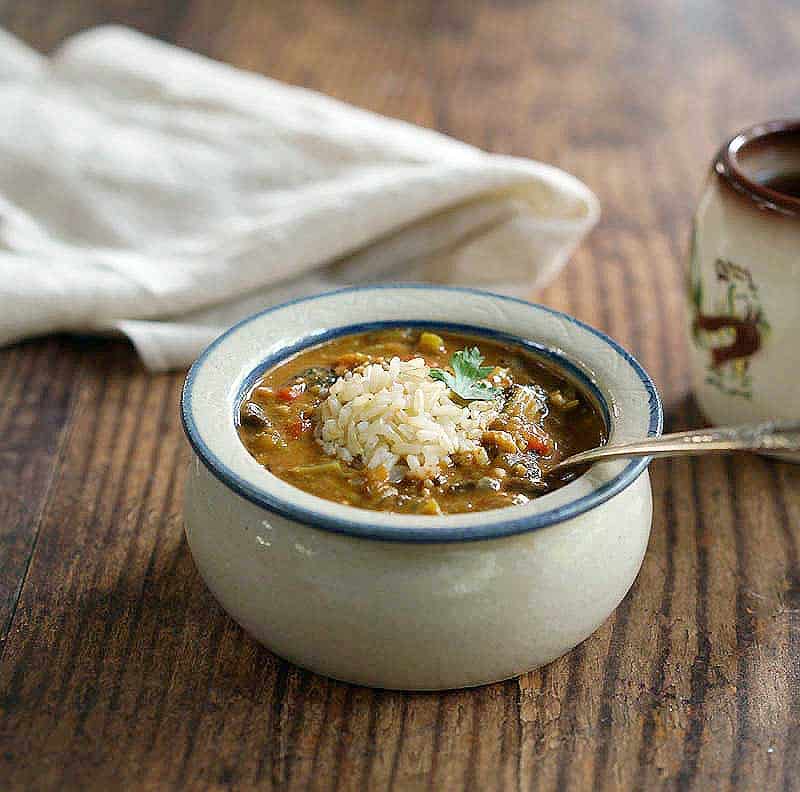 Instant Pot Oil-Free Mushroom Gumbo in a red wing pottery bowl topped with brown rice