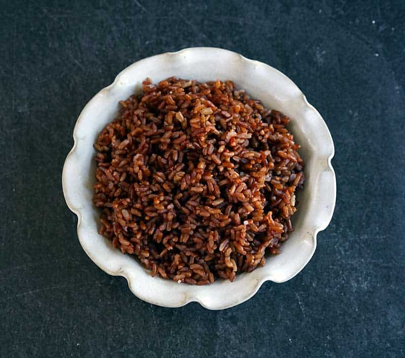 Cooked red rice in white ceramic pie plate