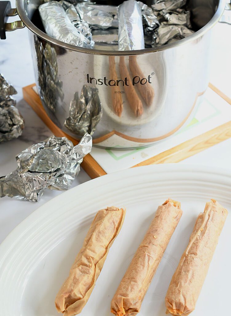 Instant Pot liner with gluten-free vegan hot dogs steamed in parchment paper and foil.