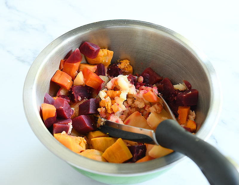 Cooked root veggies in a silver bowl.