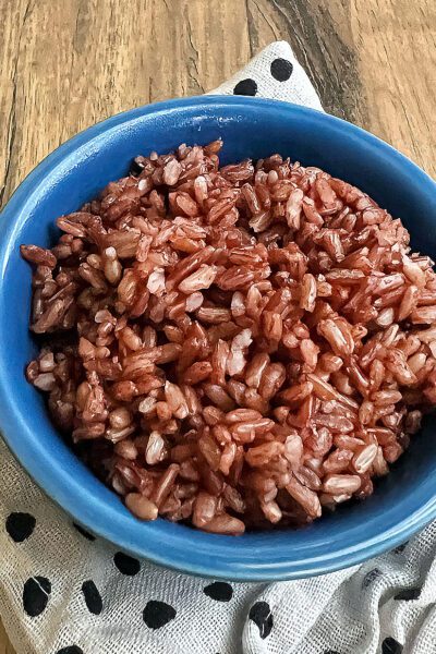 Cooked pink rice in a blue bowl.