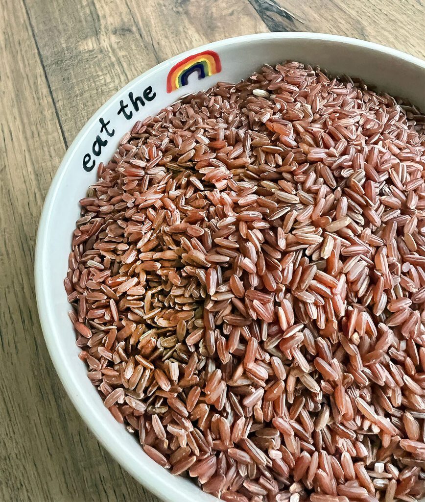 Pottery bowl of uncooked pink rice